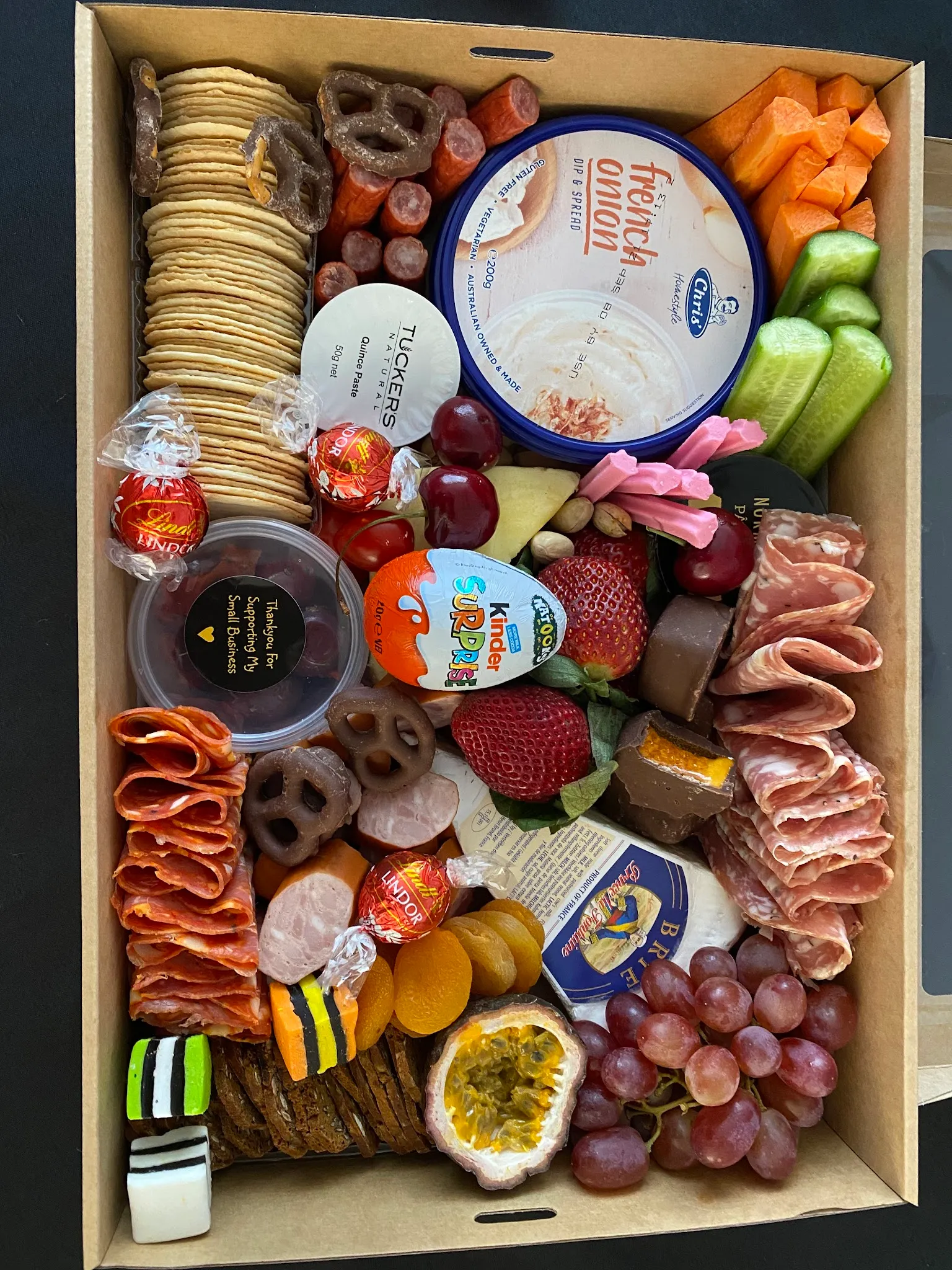 Overhead view of open Coastal Grazing box filled with charcuterie, fruit, sweets, and dips